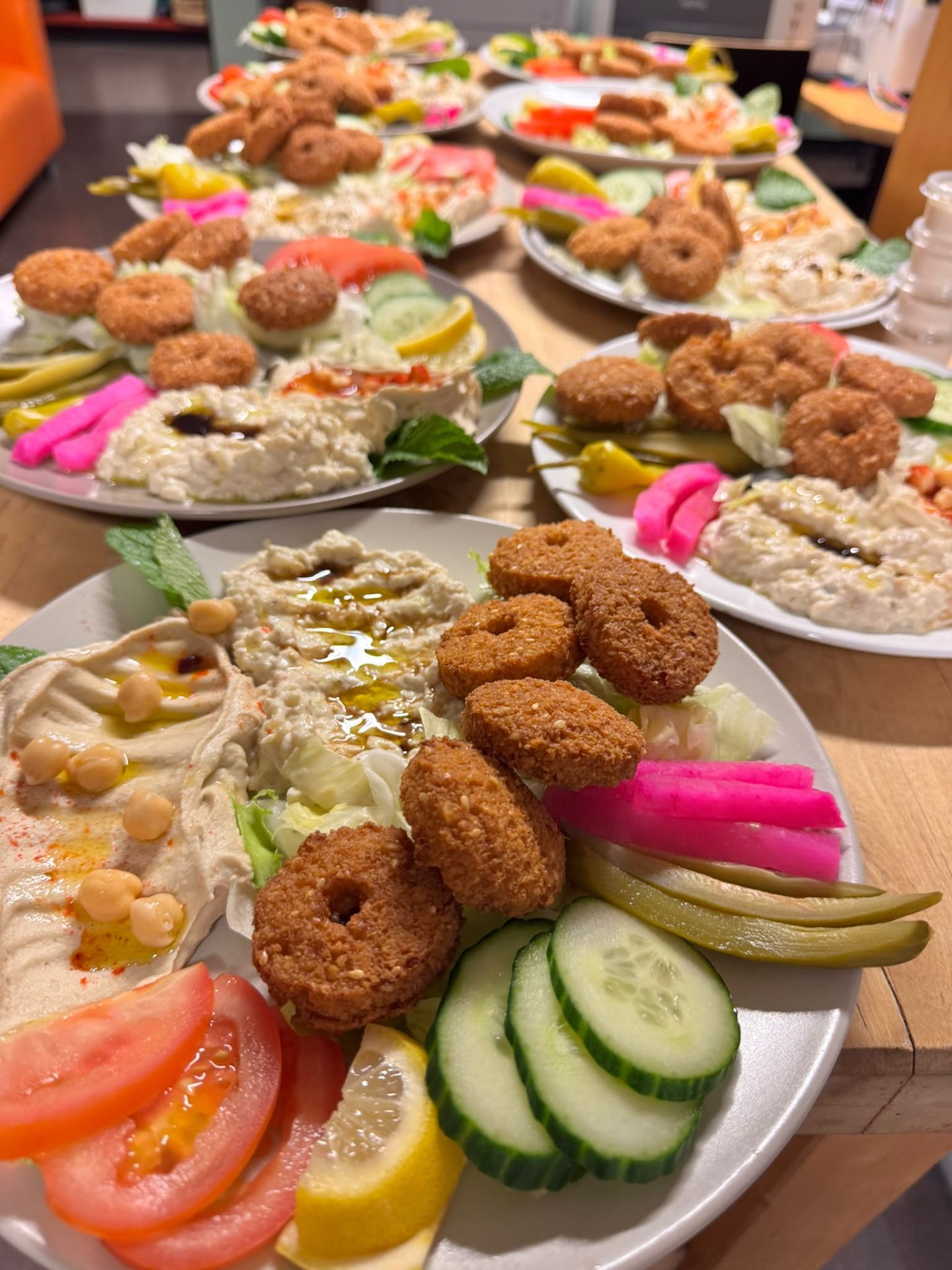 Een tafel vol verse falafel, hummus en groenten voor catering aan huis